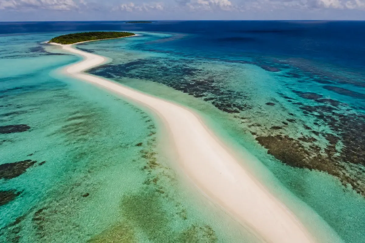Île corallienne et lagon bleu vus depuis les airs aux Maldives
